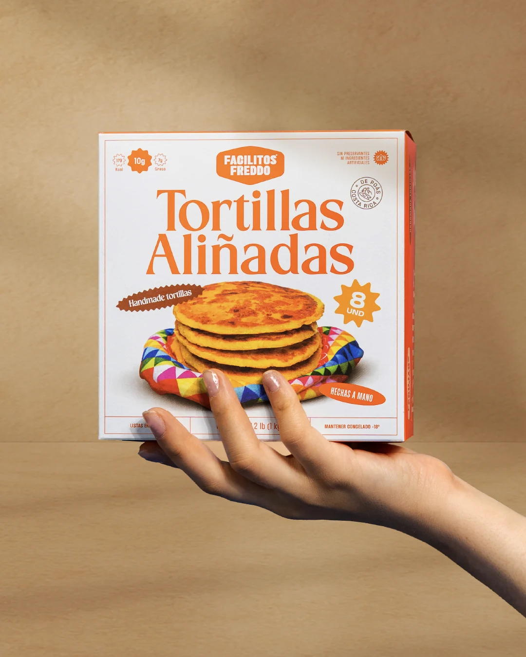 Caja de Tortillas Aliñadas Facilitos Freddo sostenida en la mano